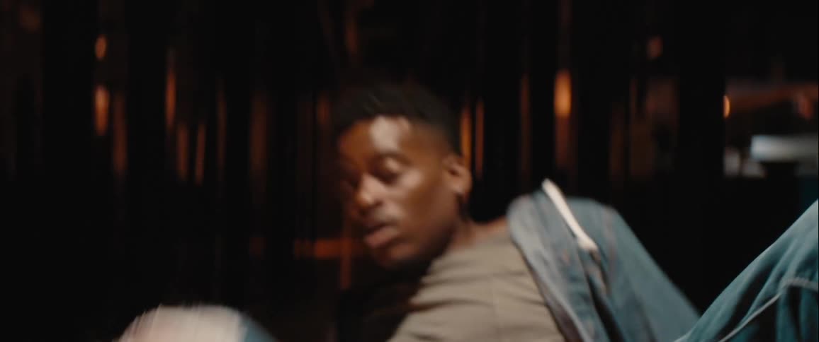 A man in a glass building looks terrified then falls backwards and runs away