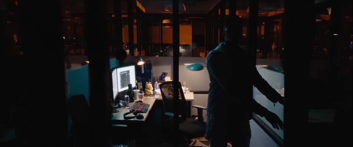 Young man entering inside an office cubicle at night and closing the door scared and then he opens the door again and looks around