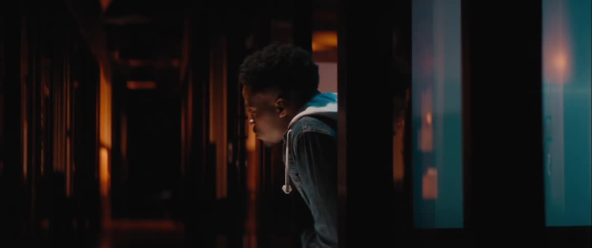 Man in a hallway looking around suspiciously