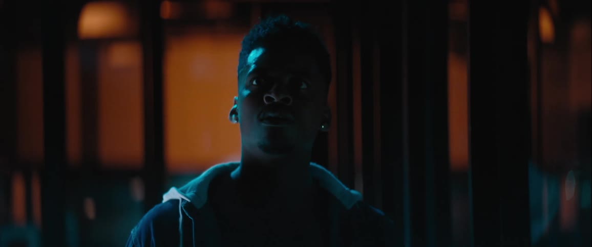 Man in a dark hallway looking around suspiciously
