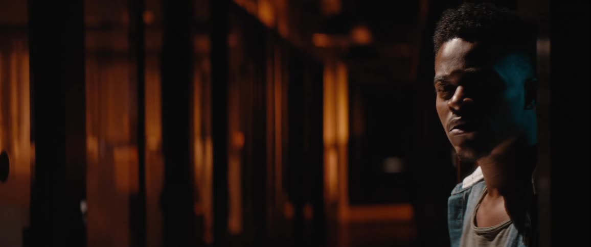 Man in a hallway looking around with a look of fear and distrust