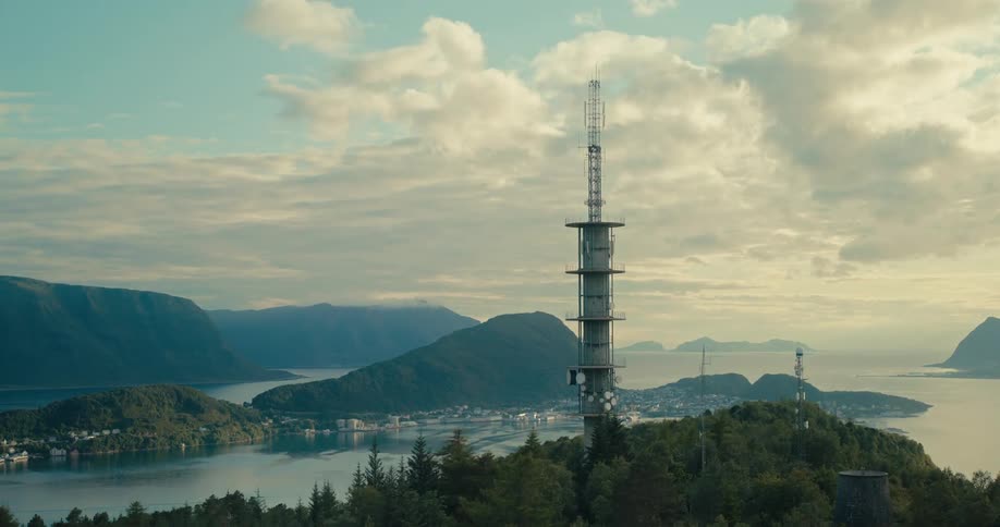 Aerial scene of an antenna on a mountain and in the background islands surrounded by the sea