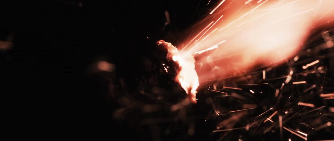 A burst of light and sparks erupts in the darkness