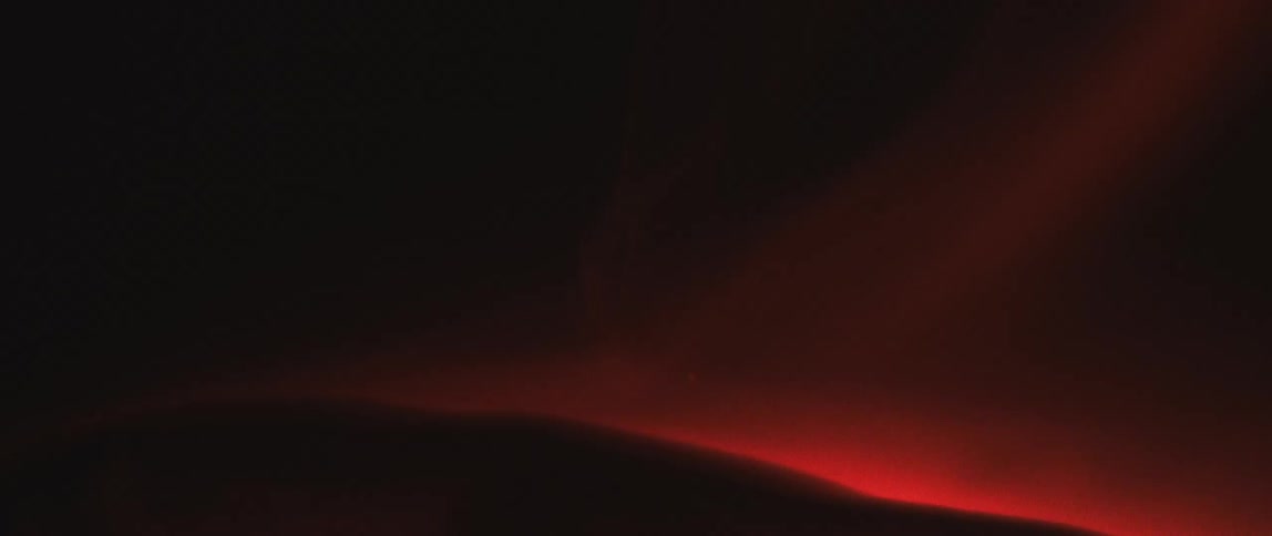 A close up of dim orange flames rising from a dark smoldering object