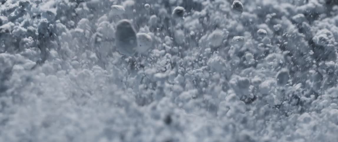 A closeup of fine powdery dust particles blasting up over a vibrating surface
