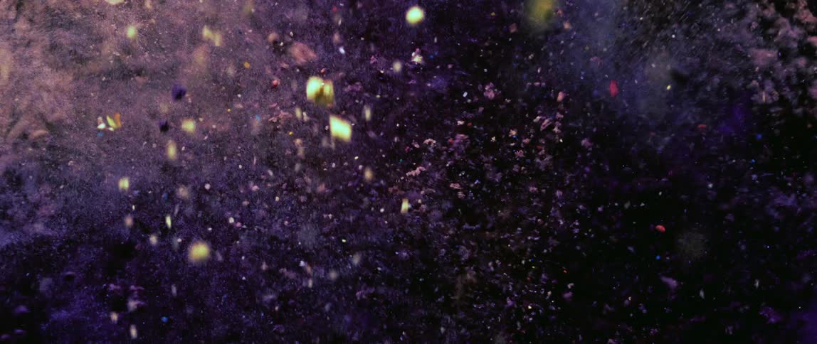 Close up of yellow powder mixing with purple colored powder abstract