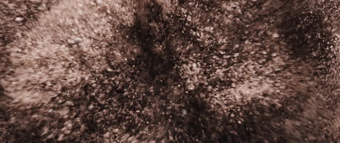 Soil particles are being disturbed creating a textured dynamic pattern