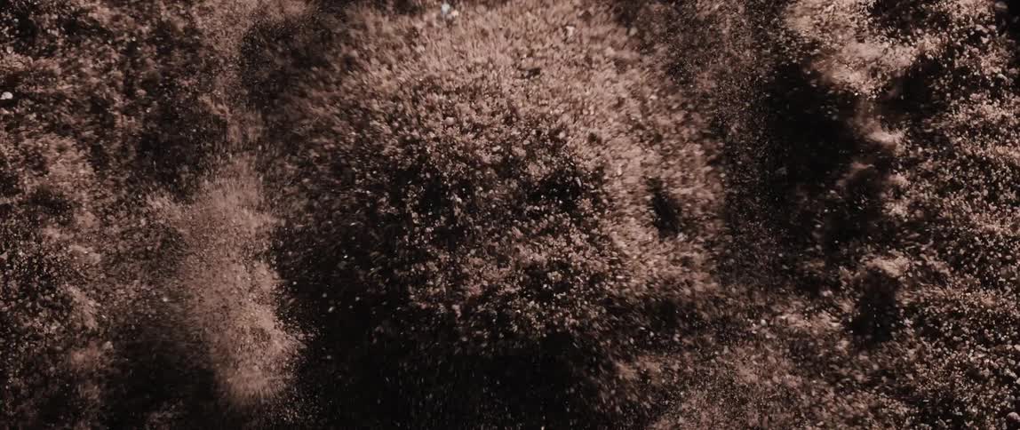 The sand rises and falls as it explodes