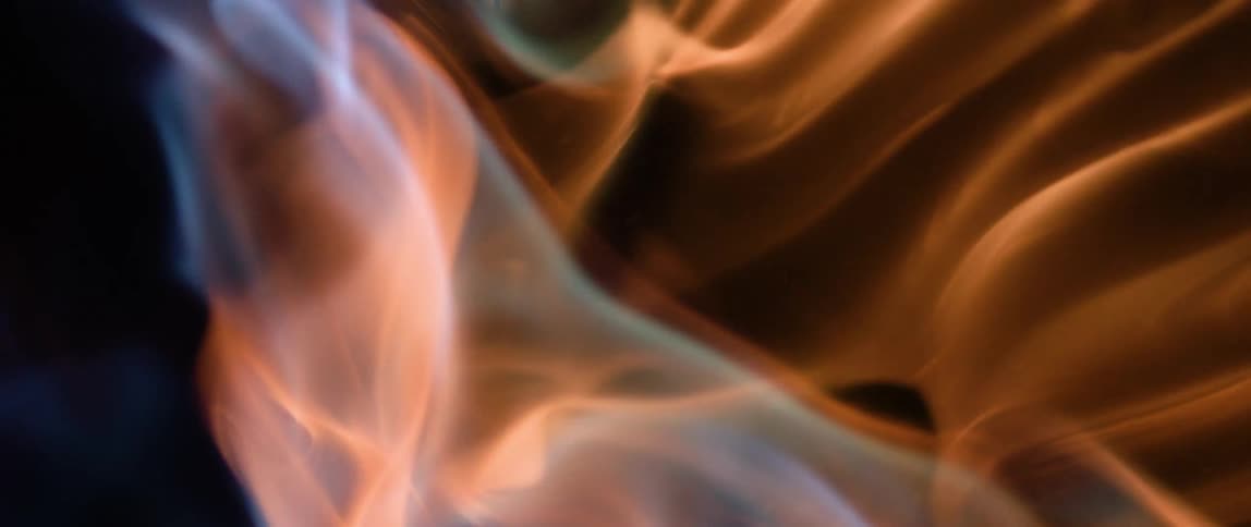 Close up of blue and red fire flames against a black background
