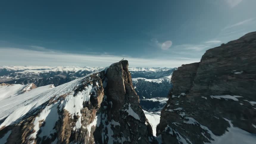 Person on top of a snowy mountain cliff