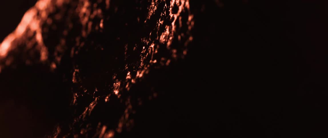 Rough dark surface is illuminated by warm light