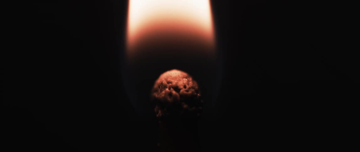 Extreme close up of a match with fire burning