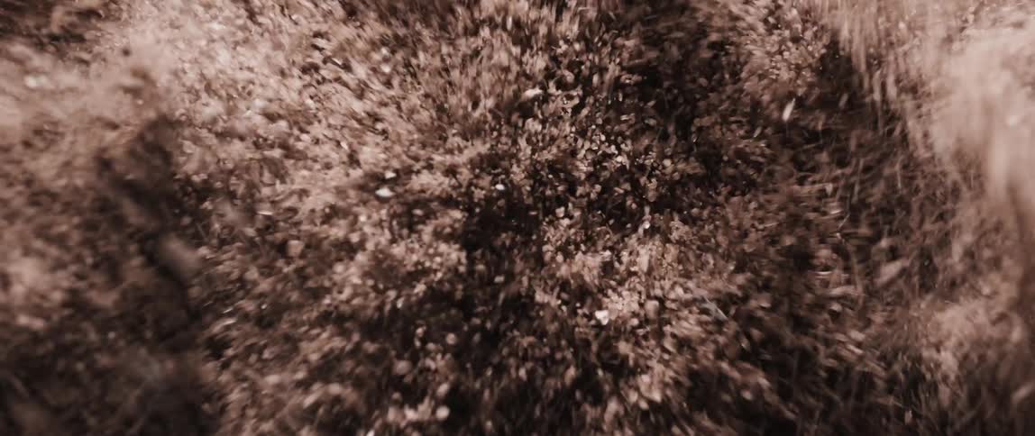 Course particles rise and fall through the air while the mass is shaken