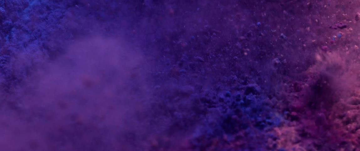 Close up of purple and violet colored powder in a shaking motion