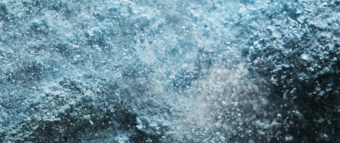 Some pale particles fly through the air while a powdery mass shakes