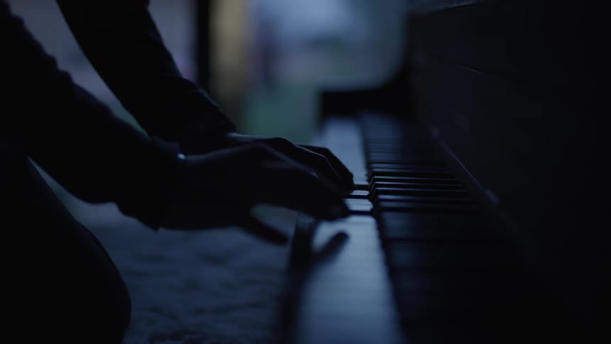 Hands gently touch the keys of a piano
