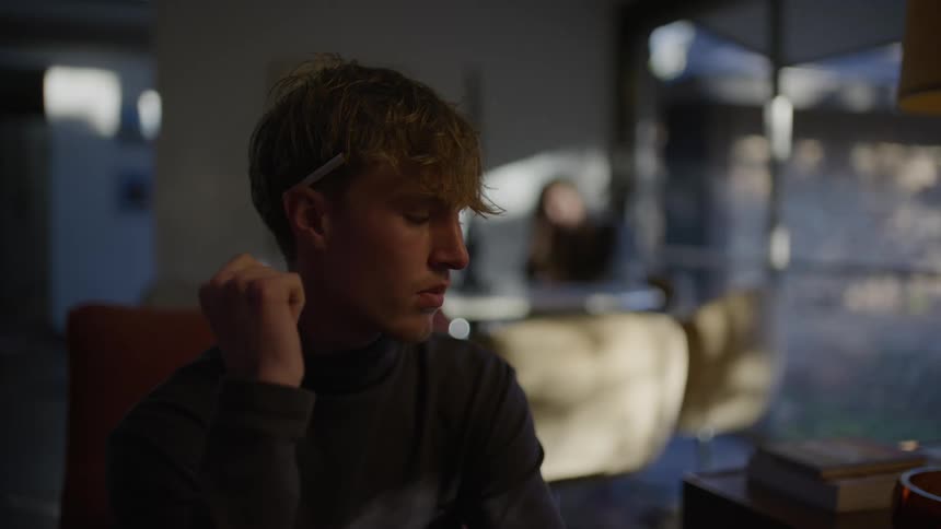 Man sitting in an armchair watches thoughtfully