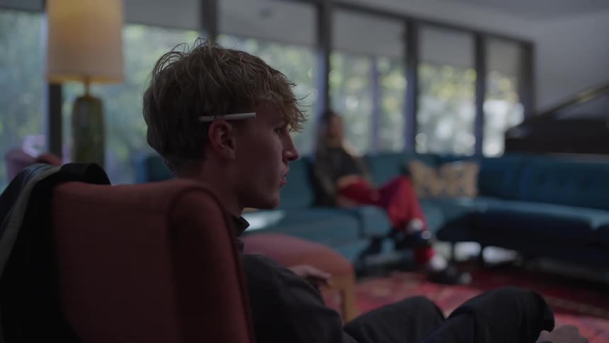 Man and a woman sitting on a separate sofa in a room