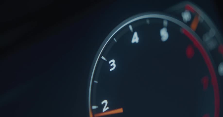 A closeup shot captures a cars digital odometer shaking violently as the rpm revs up starting from 0 and increasing to 3 on the dashboard gauge