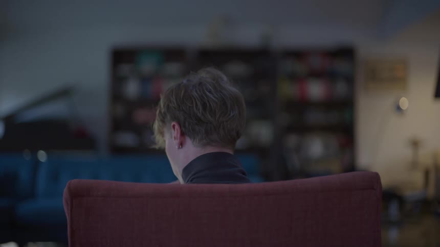 A man is sitting in a chair in a living room