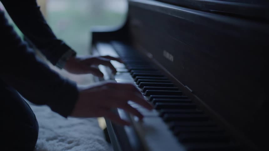A persons hand calmly typing the keys on a black keyboard