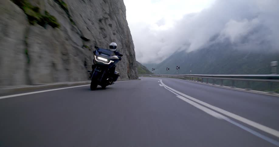 Motorcyclist leans into a sharp curve on a mountain road
