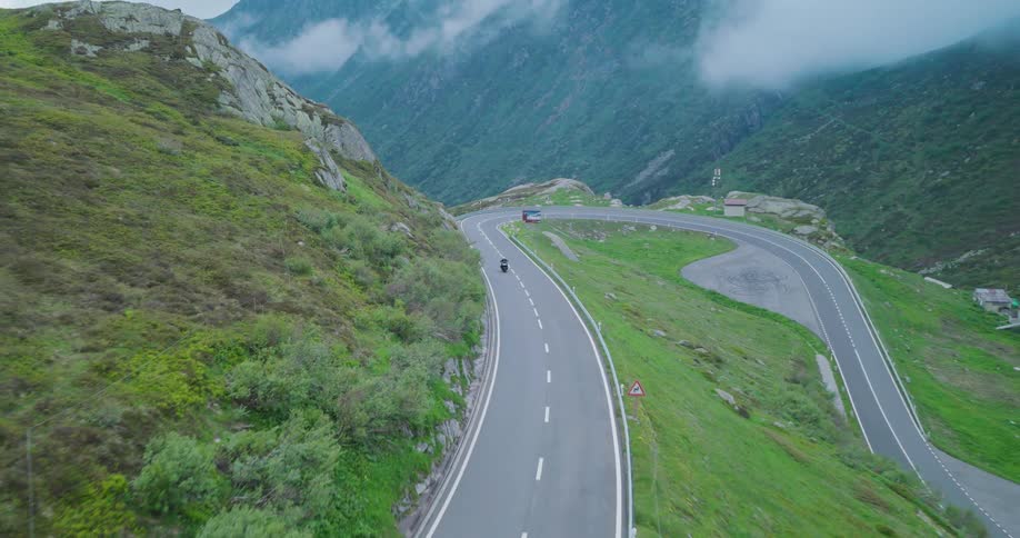 A motorcycle drives up the road on the mountain