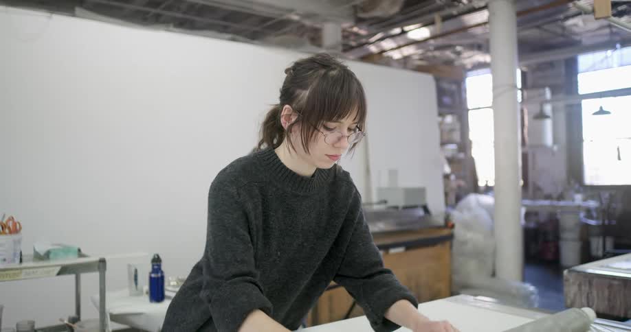 A young woman is rolling textile fabric on a tube