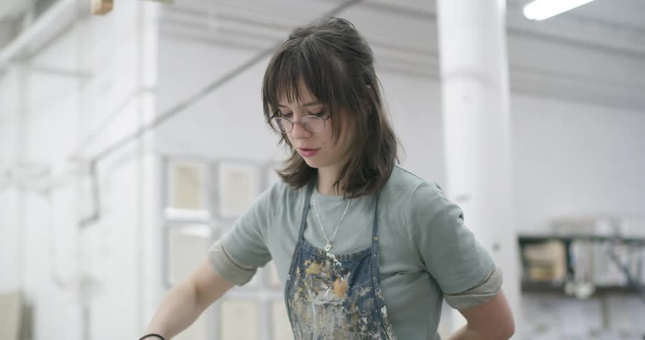 A woman looks down at she moves one arm