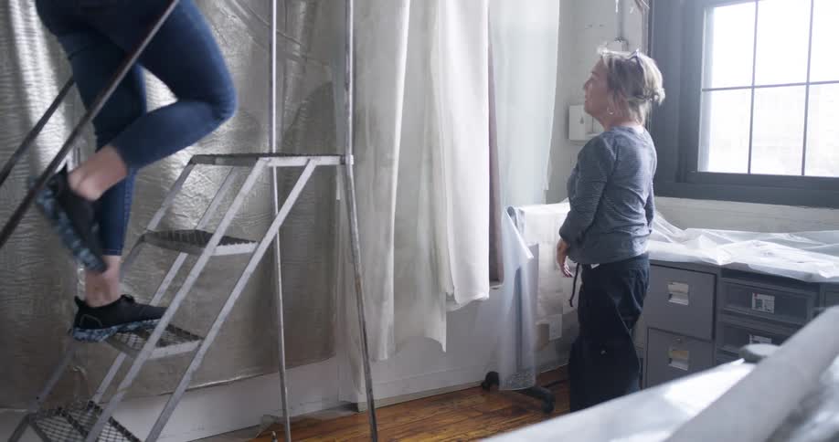 Two women are doing the prep work before painting the kitchen walls