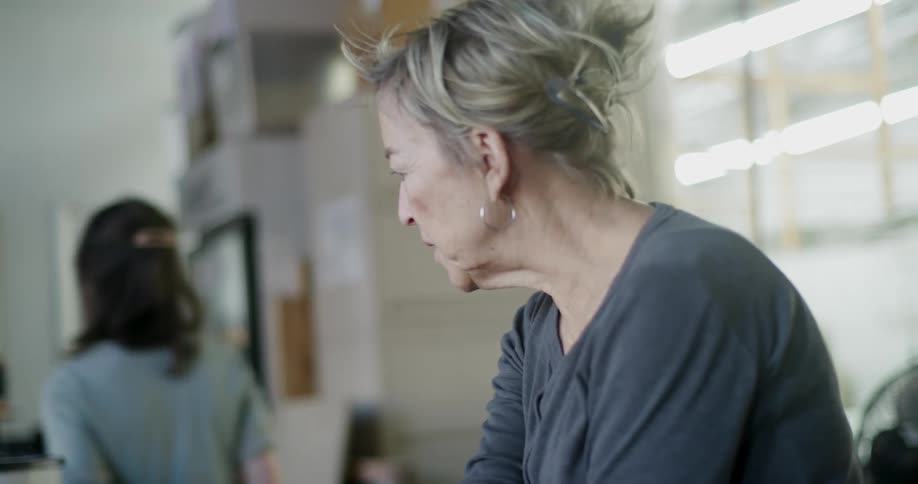 A woman walks up and talks to another woman in a business