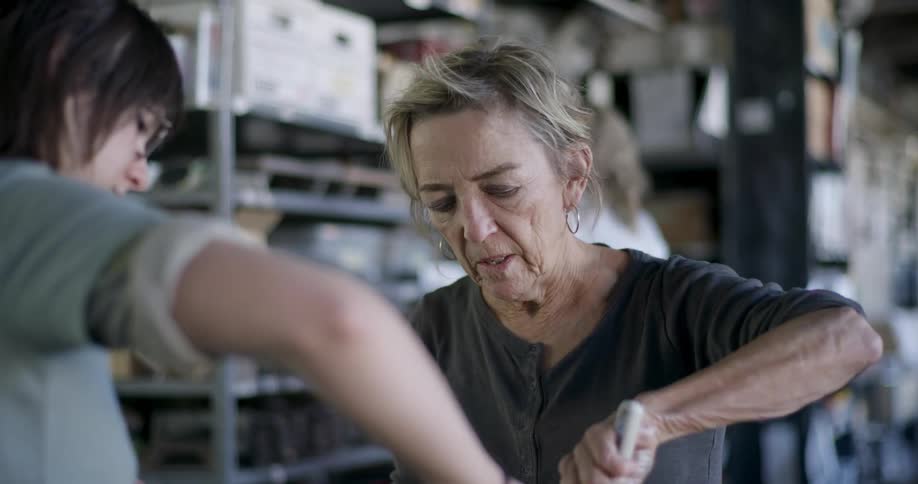 Female coworkers create a mixture while working in a workshop