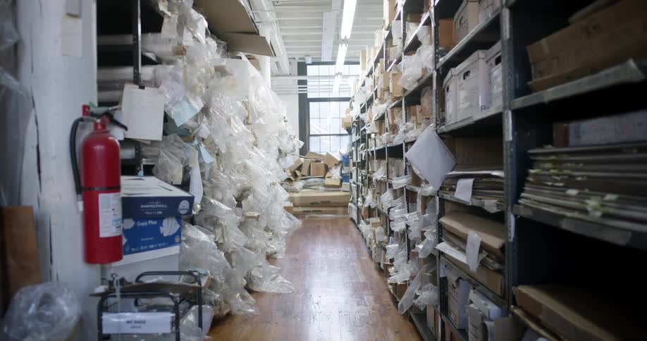 Interior of a warehouse with disorganized boxes and bags on shelves