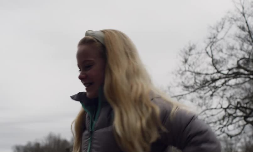 A clip of a girl putting a log on the fire