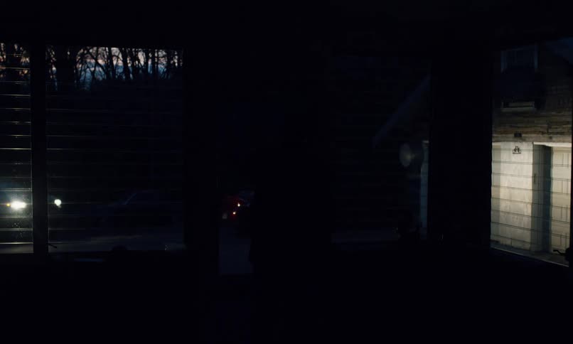 Man stands in the doorway while waving away the guest driving away at night