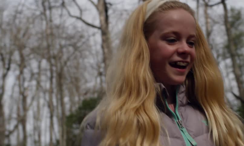 A girl boy and older man walk through the woods the girl excitedly talks to the boy