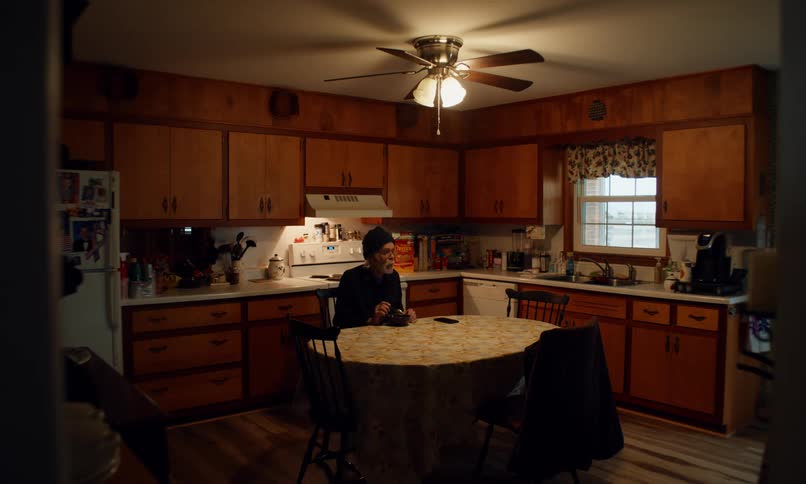 Elderly man sitting at table eating