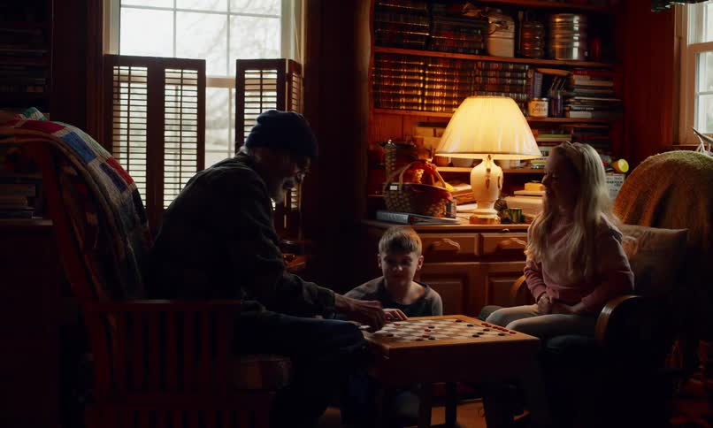 Grandpa playing board game with his two grandchildren and clapping their hands together