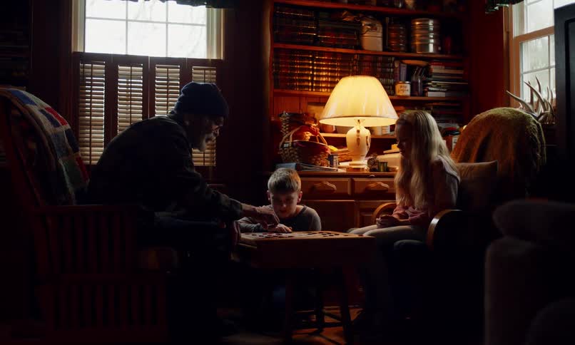 Grandfather plays a board game with his grandchildren