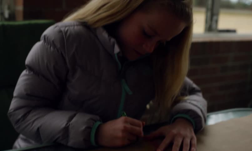 A clip of a girl coloring a rainbow with crayons