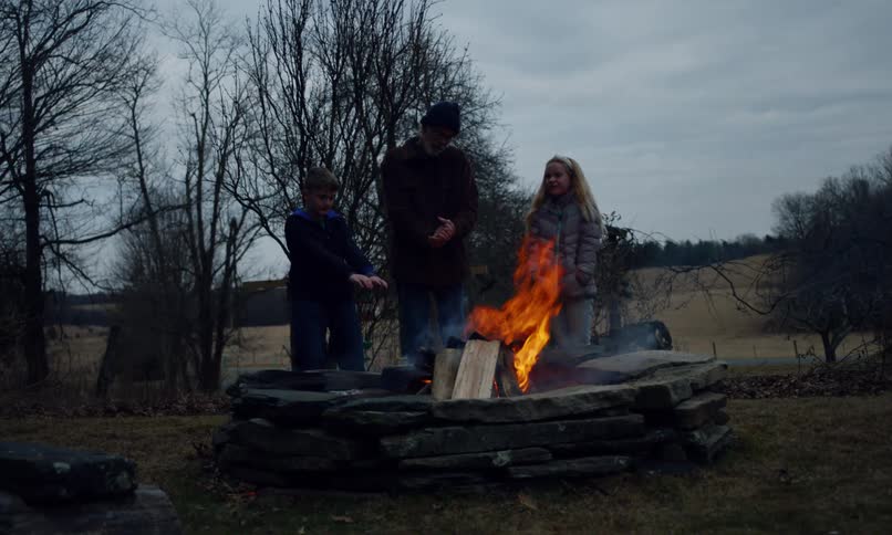 A clip of people standing beside a burning fire