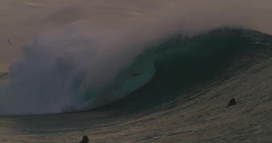 Surfers riding a tubular wave in the ocean