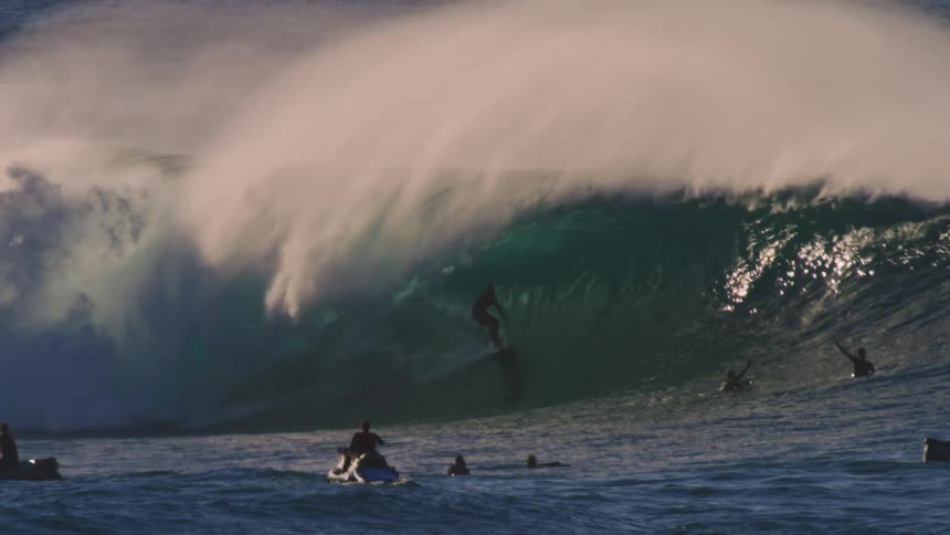 People enjoy waves in the ocean on surfboards and jet skis