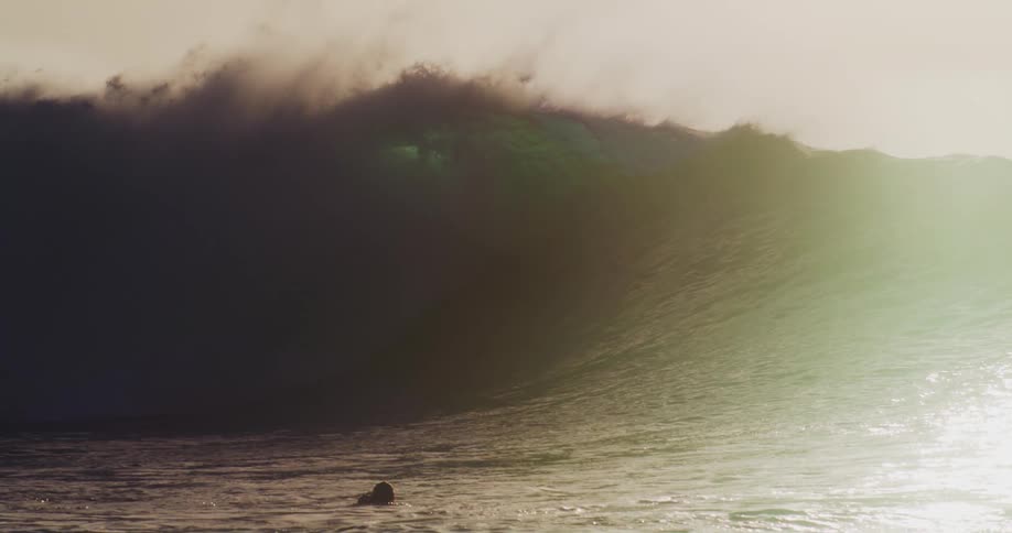 Surfers wait on their boards for a large wave to ride