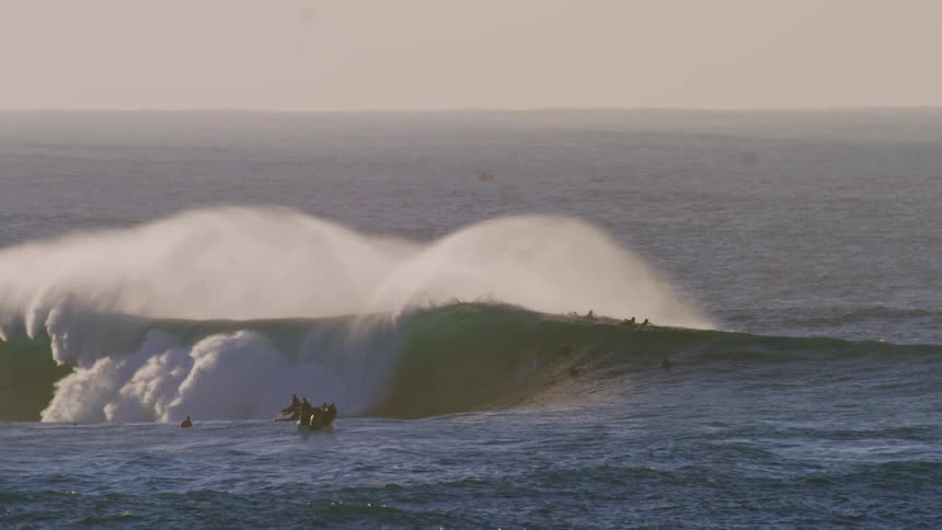 Group of surfers and people on jet skis in the ocean