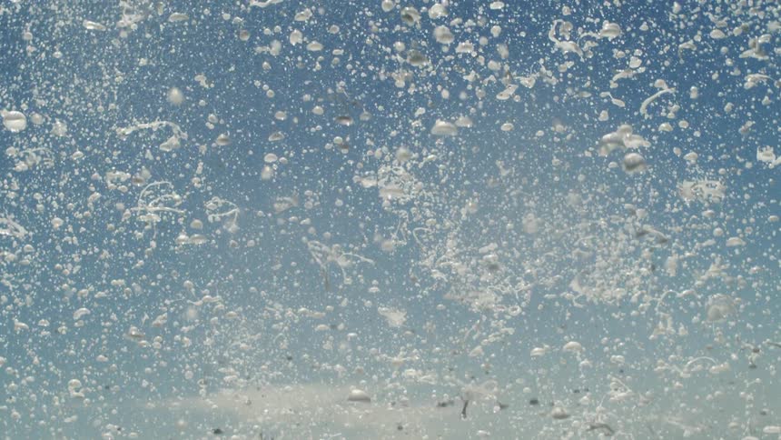 Foam with falling water against a blue sky