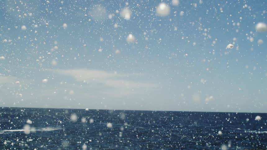 Water with foam falling and the ocean in the background