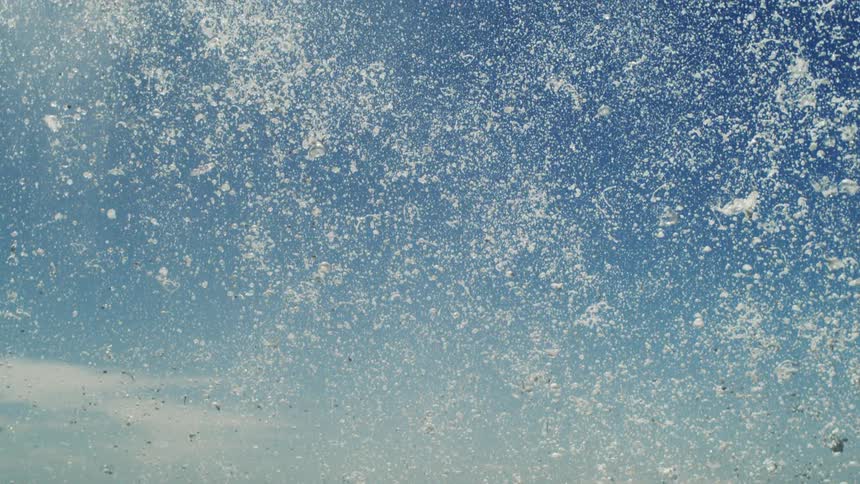 Foamy water in free fall against a blue sky