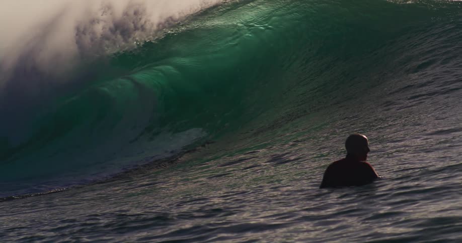 Person with a professional camera from inside the sea filming a tubular wave