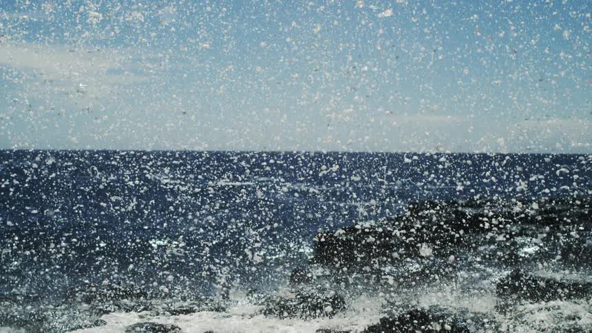 Upward view of a blue sky with water and foam falling